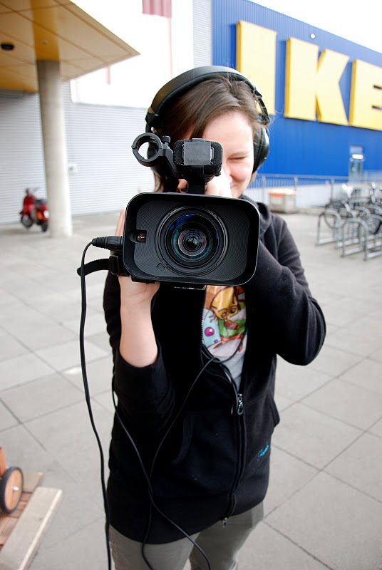 Foto, eine junge Frau hält eine Kamera in der Hand.